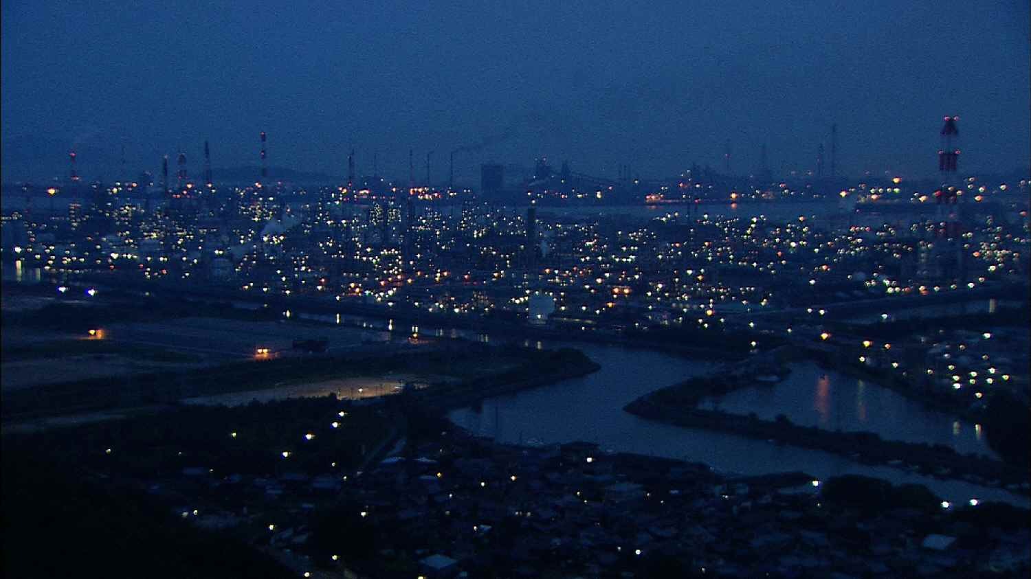 色とりどりの光と煙突からの煙の夜景がダイナミック