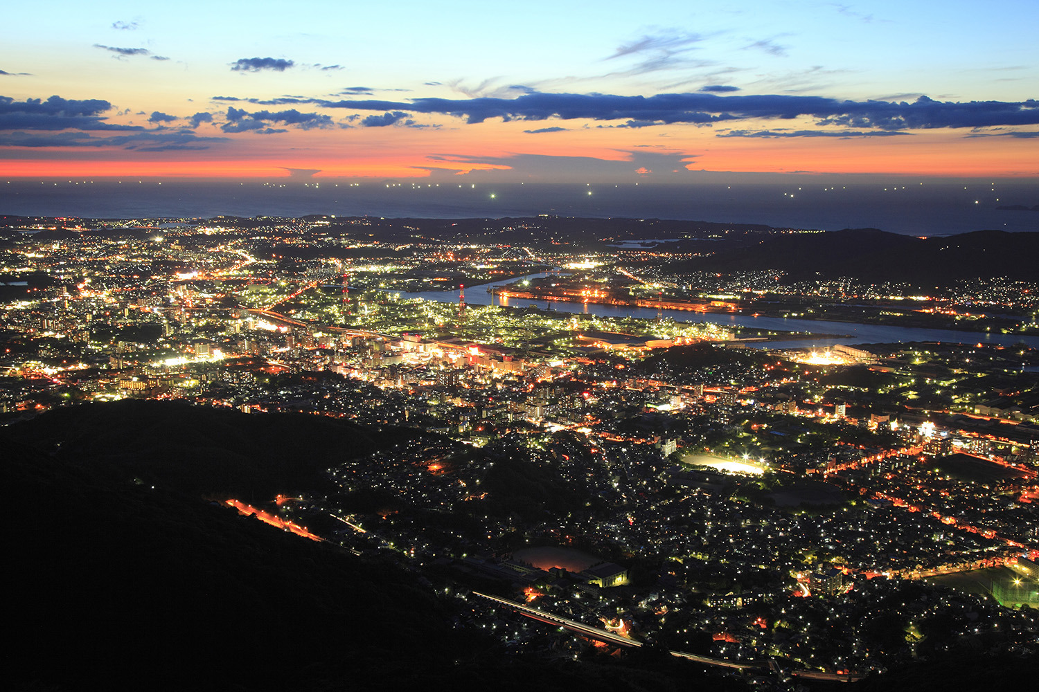 夜の海が金色に輝く北九州市街の明かりを際立たせる