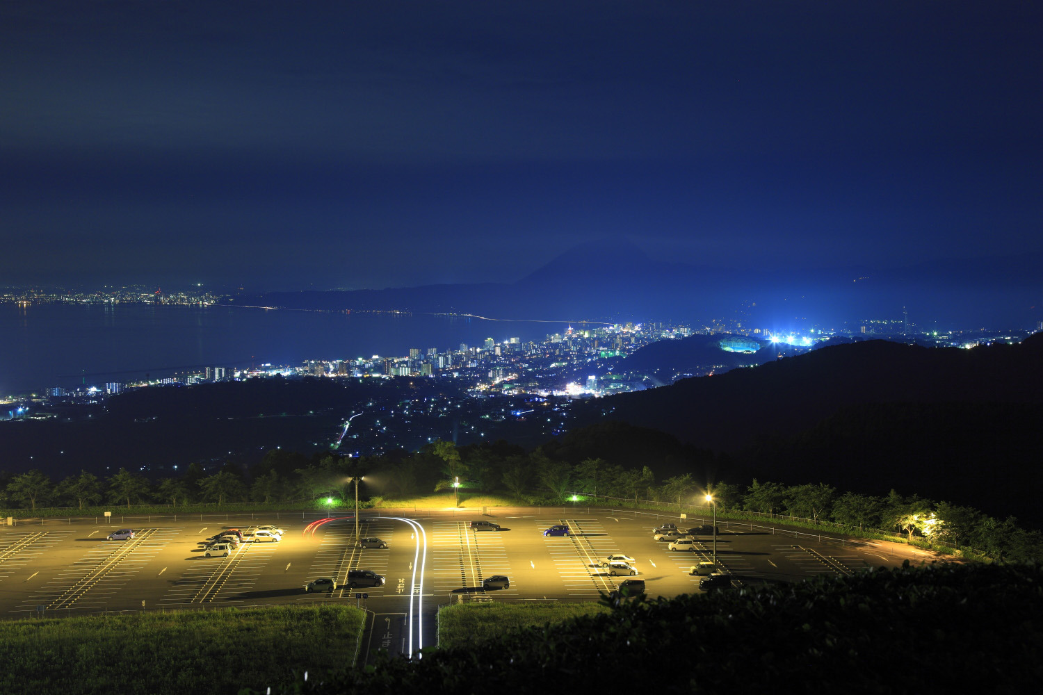 高崎山のシルエットを背景に別府湾沿いに街明かりが広がる