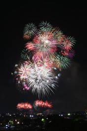 祭り会場の上空で大きな花火が開く