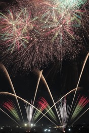 祭り会場の上空で大きな花火が開く
