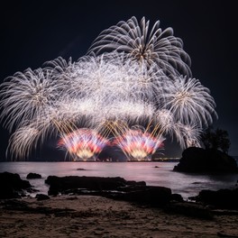 海辺を彩る壮大な花火ショーが冬の夜空を照らす