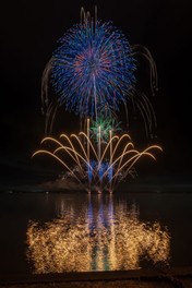水面に映し出された花火が会場を幻想的な空間に包み込む