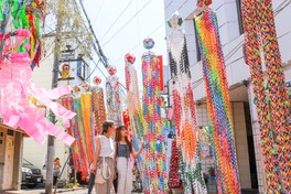 色とりどりの竹飾りが夏空に映える街なかの光景