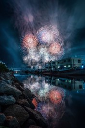 夜空と海を染める華やかな大輪