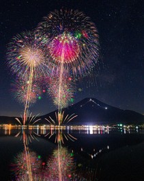 富士山と星空を背景に咲く大輪