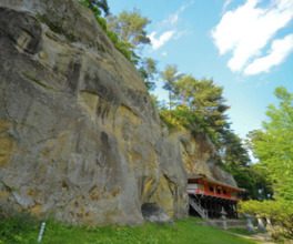 毘沙門堂と岩面大仏。面大仏は約16.5ｍもの大像で北限の磨崖仏として名高い