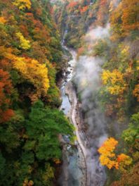 紅葉でカラフルに染まった渓谷を流れる皆瀬川