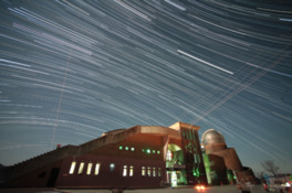 天の川の星々がまるで光の滝のように見える夜の天文台