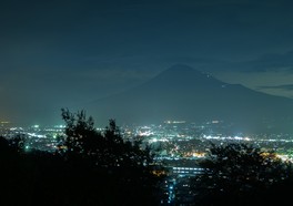 ぼんやりと浮かび上がる富士山のシルエットと街の灯りのコントラストが幻想的