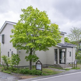 軽井沢の草花に囲まれた2階建ての白い建物