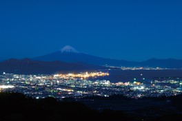 清水区や清水港の明かりのバックに富士山がそびえる